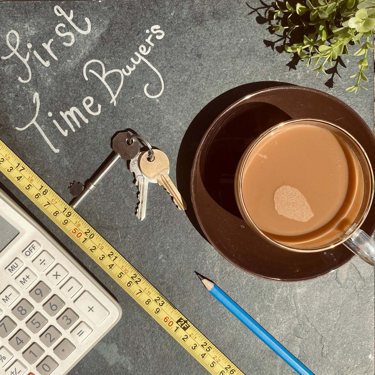 Taschenrechner mit Schlüsseln und Kaffee
